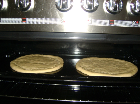 Pizza dough rising in an unlit oven for 30 minutes.